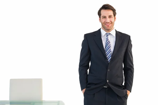 Hombre de negocios sonriente de pie con las manos en los bolsillos — Foto de Stock