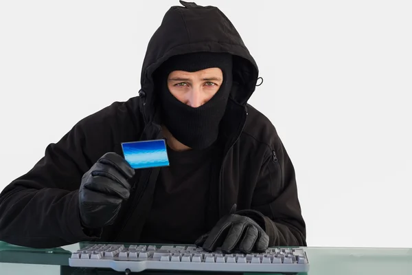 Burglar shopping online with laptop while looking at camera — Stock Photo, Image