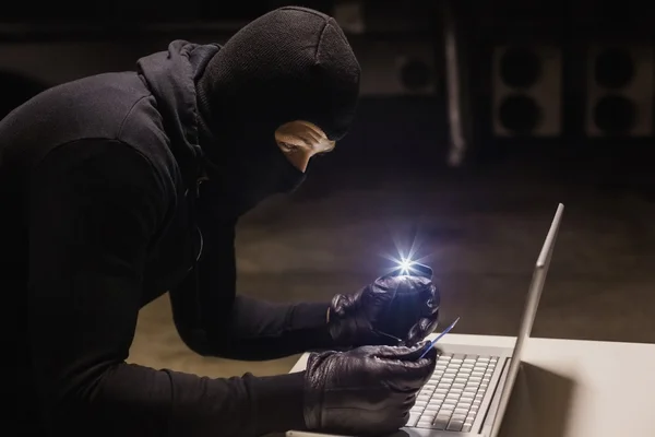 Грабитель делает покупки в Интернете, делая свет с его телефона — стоковое фото
