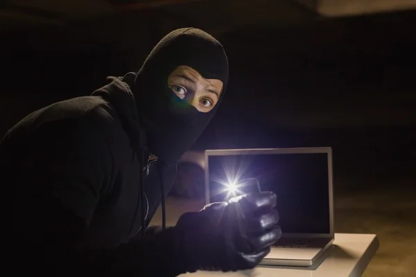 Rånare tittar på kameran samtidigt som ljus med sin telefon — Stockfoto