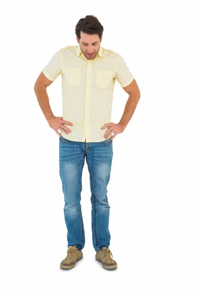 Handsome man standing and looking on the floor — Stock Photo, Image