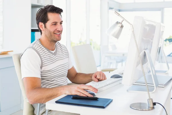 Χαμογελώντας casual νεαρός άνδρας που χρησιμοποιούν τον υπολογιστή — Φωτογραφία Αρχείου