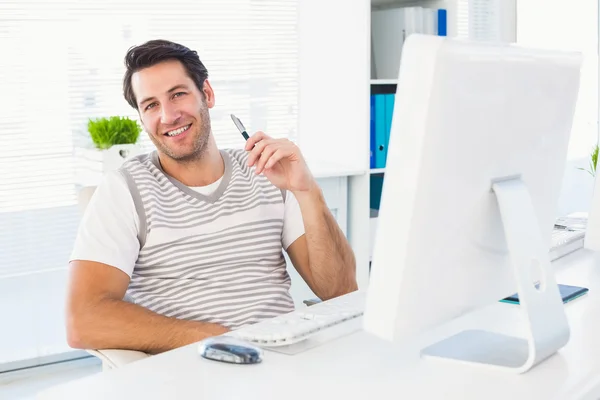 Homme souriant avec ordinateur dans un bureau lumineux — Photo