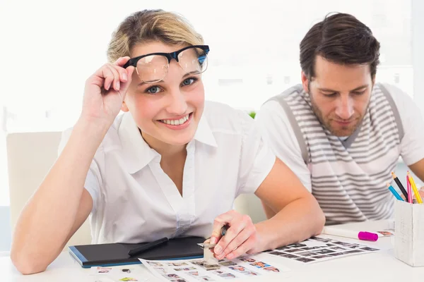 Editor using magnifying loupe while looking at camera — Stock Photo, Image