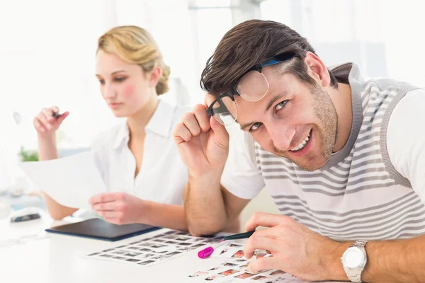 -Editor met behulp van vergrotende loep tijdens het kijken naar camera — Stockfoto