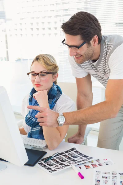 Cheerful photo editor pointing at a computer — Stock Photo, Image