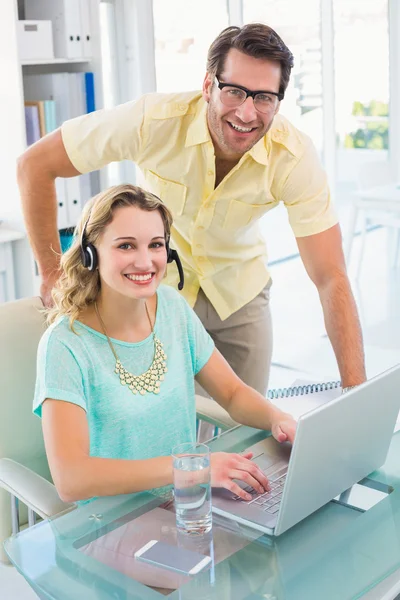 Porträt einer Frau mit Kopfhörer und ihrem Kollegen — Stockfoto