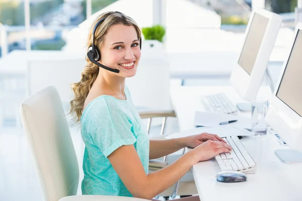 Jolie agente du centre d'appels assise à son bureau pour un appel — Photo