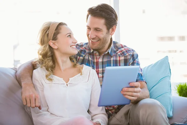 Casal usando tablet pc enquanto olham um para o outro — Fotografia de Stock