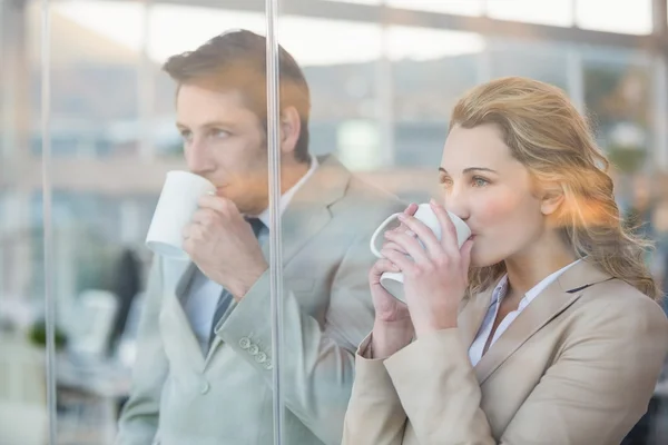 Business people drinking cup of coffee through the window — Stock Photo, Image