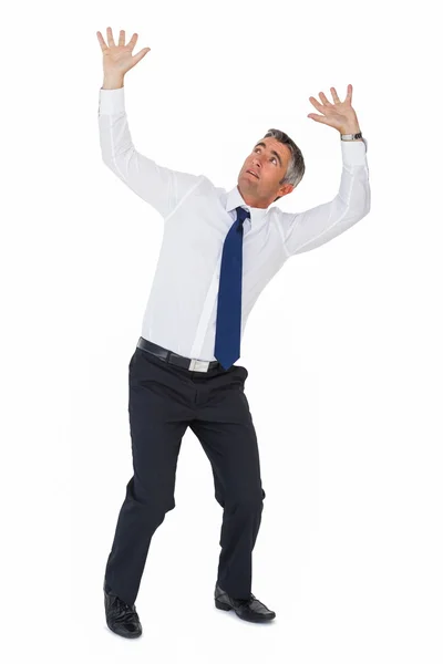 Бизнесмен с поднятыми руками смотрит вверх — стоковое фото