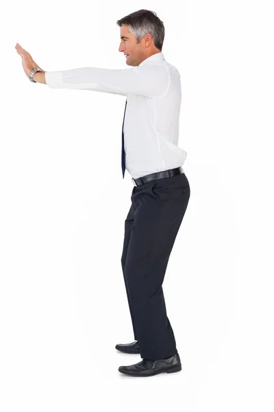 Side view of a businessman pushing — Stock Photo, Image