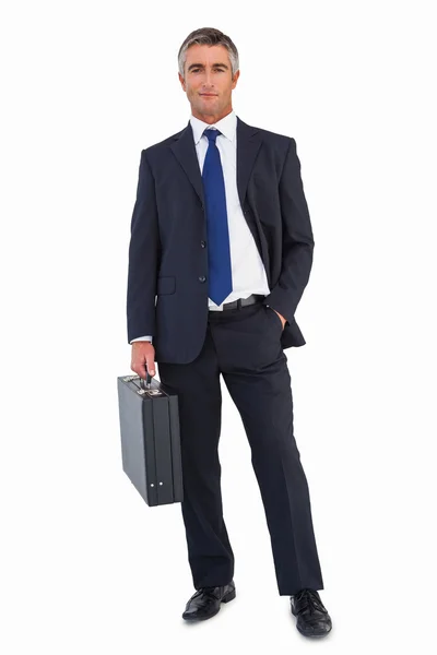 Hombre de negocios sonriente sosteniendo maletín negro — Foto de Stock