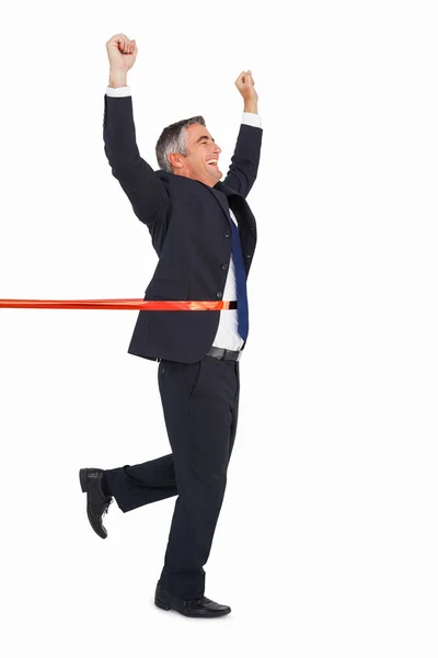 Happy businessman crossing finishing line — Stock Photo, Image