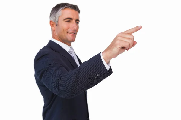 Hombre de negocios sonriente en traje señalando — Foto de Stock