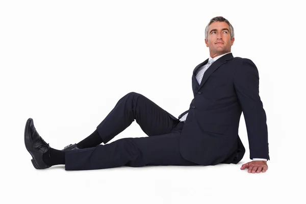 Smiling businessman sitting on the floor — Stock Photo, Image