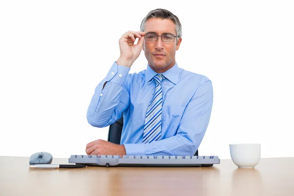 Empresário segurando seus óculos e usando teclado — Fotografia de Stock