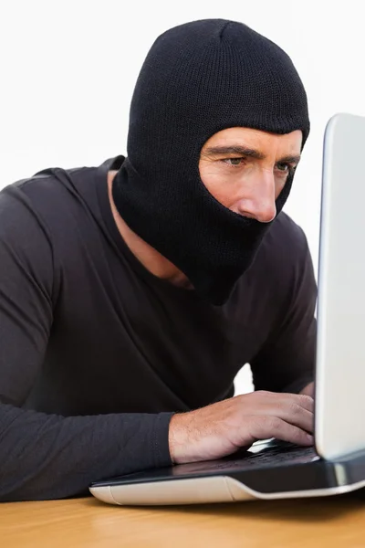 Ladrão com balaclava usando laptop — Fotografia de Stock