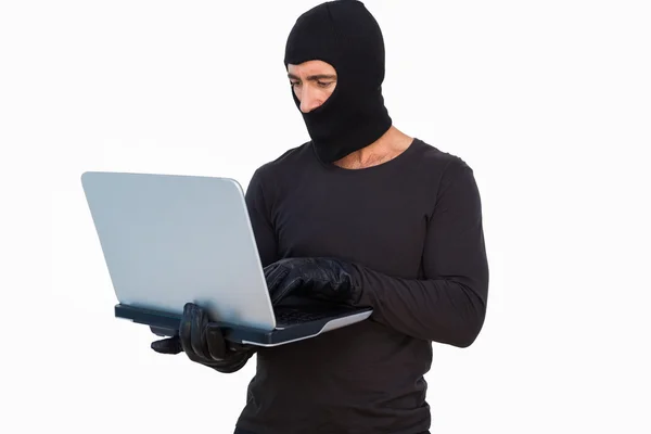 Inbrottstjuv med läderhandskar använder laptop — Stockfoto