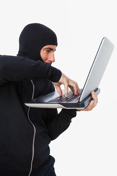 Ladrão com balaclava hackear um laptop — Fotografia de Stock