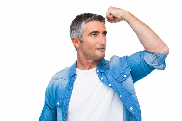 Man with grey hair tensing arm muscle — Stock Photo, Image