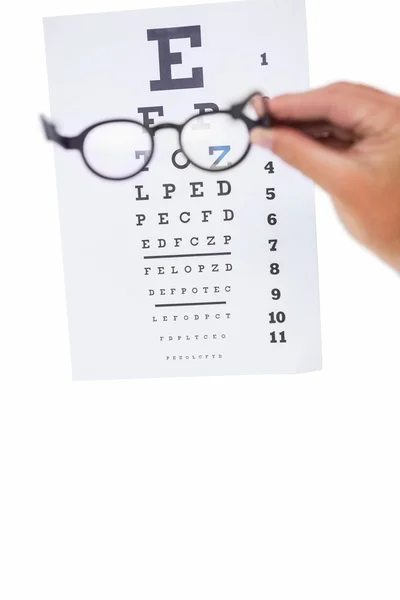 Hand holding glasses for a eye test — Stock Photo, Image