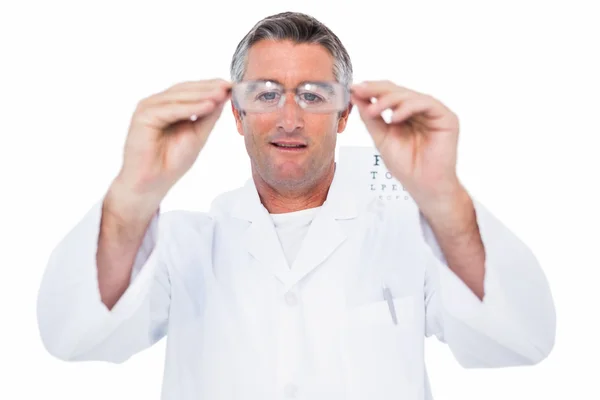 Optician in coat holding glasses — Stock Photo, Image
