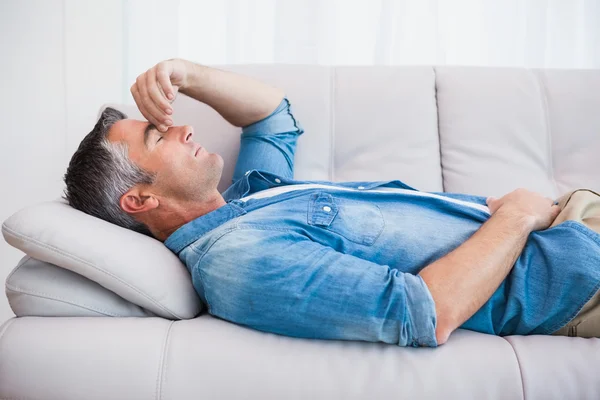 Homem com cabelos grisalhos relaxando no sofá — Fotografia de Stock
