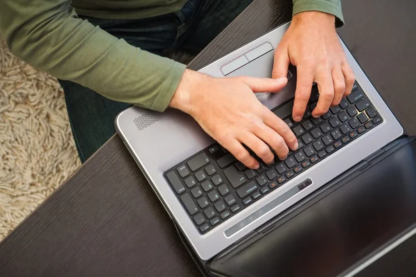 Hög vinkel syn på en man att skriva på laptop — Stockfoto