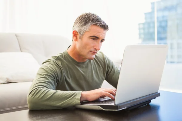 使用笔记本电脑的灰色头发的集中的男人 — 图库照片