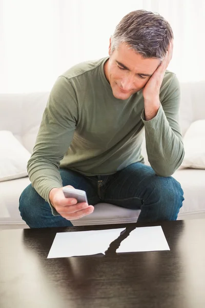Smiling man using mobile phone near ripped paper — Stock Photo, Image