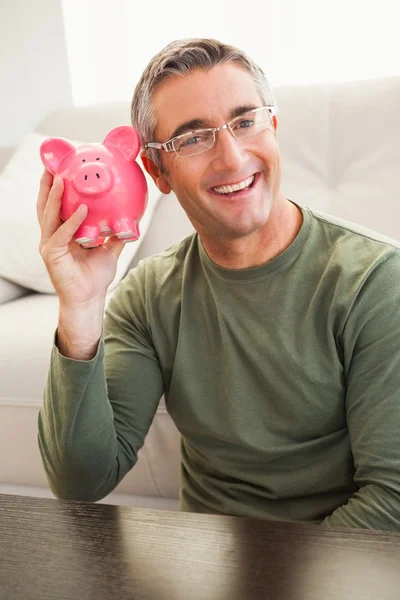 Glimlachende man poseren met een piggy bank — Stockfoto