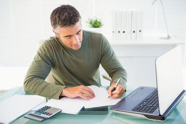 Mann arbeitet mit Laptop und schreibt — Stockfoto