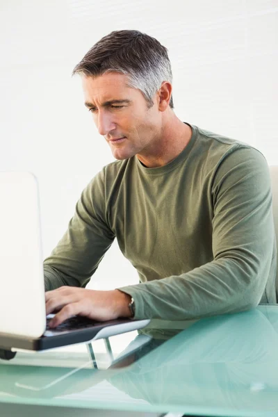 Koncentrerad casual man använder laptop — Stockfoto