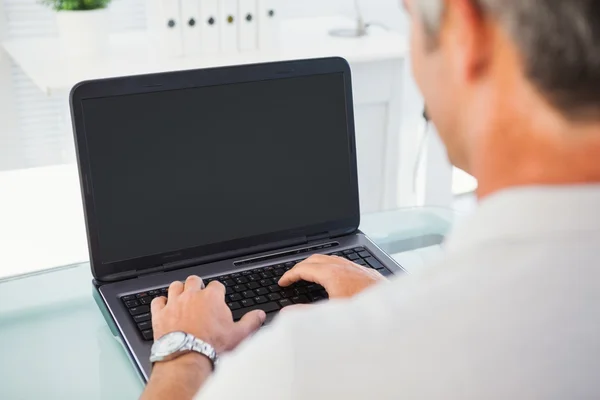 Dizüstü bilgisayarda yazarak gri saçlı adam — Stok fotoğraf