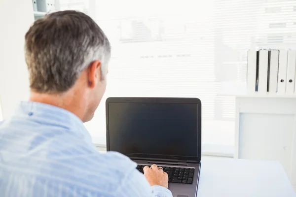 Man med grått hår använder sin laptop — Stockfoto