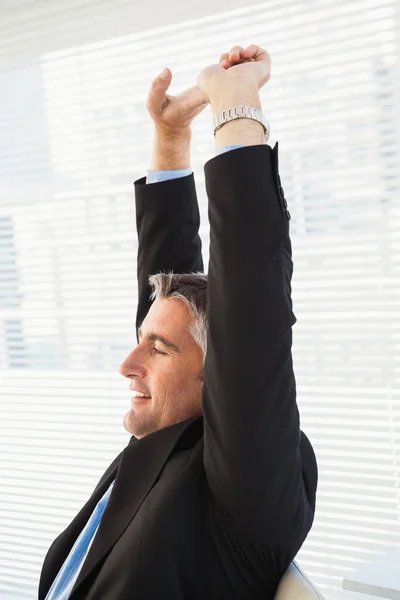 Peaceful businessman stretching his arms — Stock Photo, Image