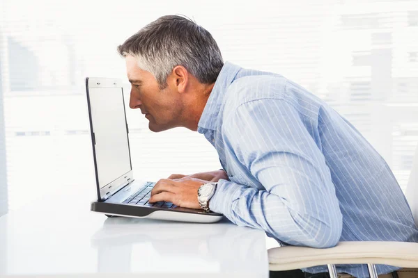 Businessman looking closely at the laptop — Stock Photo, Image