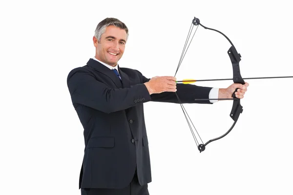 Smiling businessman stretching a bow — Stock Photo, Image