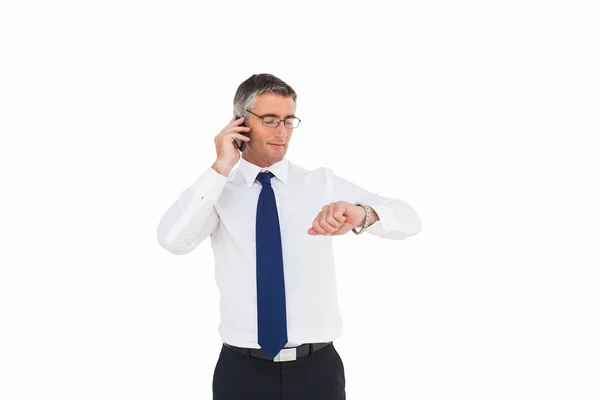 Biznesmen w telefonie patrząc na jego zegarek na rękę — Zdjęcie stockowe