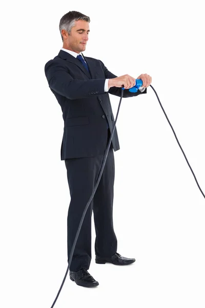 Smiling businessman connecting cables together — Stock Photo, Image