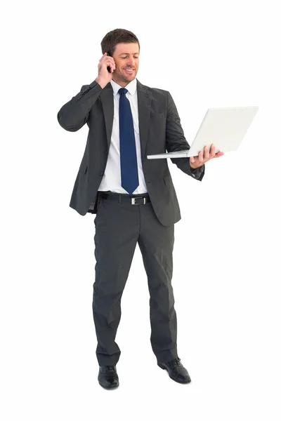 Biznesmen rozmowy na telefon trzyma laptopa — Zdjęcie stockowe
