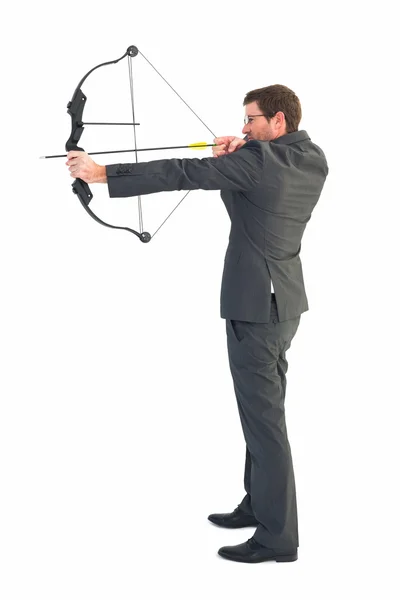 Businessman shooting a bow and arrow — Stock Photo, Image