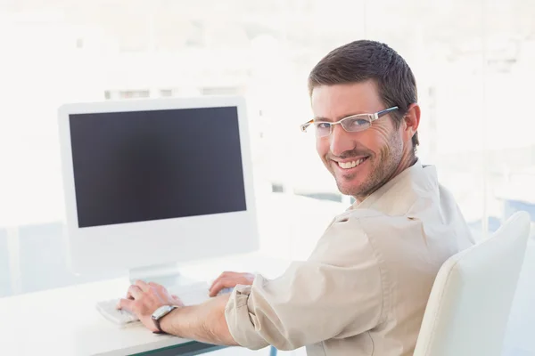 Sorrindo empresário casual em sua mesa — Fotografia de Stock