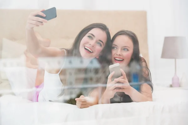 Söt vänner att ta en selfie på sängen — Stockfoto