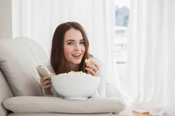 Morena bonita assistindo tv com pipocas — Fotografia de Stock