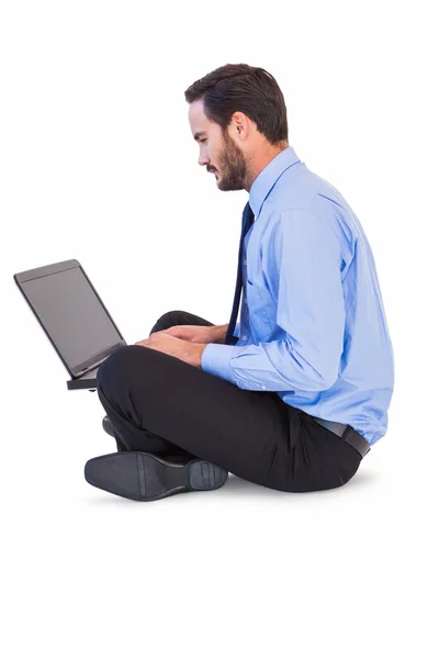 Businessman sitting on the floor using his laptop — Stock Photo, Image