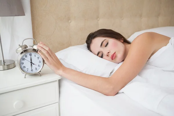 Pretty brunette turning off her alarm — Stock Photo, Image