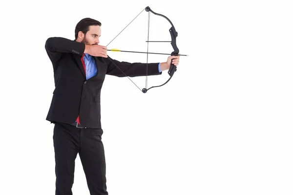 Hombre de negocios enfocado disparando un arco y flecha — Foto de Stock