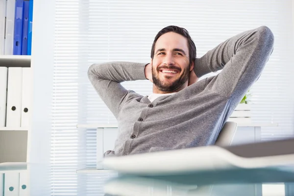Relaxed casual businessman leaning back at his desk — Stock Photo, Image